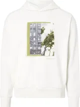 Buzo blanco de algodón con capucha y cordones ajustables. Estampado rectangular en el frente con fotografía de edificio y vegetación. Logo de Calvin Klein estampado debajo de la imagen.