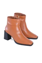 Botines de cuero color caramelo, con caña media, cierre lateral y puntera cuadrada. El tacón es bloque de color negro de aproximadamente 7 cm.
