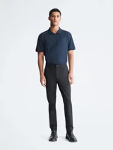 Pantalón chino de corte slim color negro, con bolsillos laterales y traseros, cierre con cremallera y botón, y trabillas para cinturón.