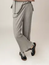 Pantalón gris de punto canalé, corte palazzo y cintura alta elástica.
