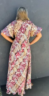 Vestido largo de seda con estampado paisley en tonos marrón, rojo oscuro y azul. Presenta escote en V y mangas cortas con volado.