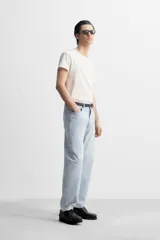 Pantalón de jean gris de corte recto, con cinco bolsillos, efecto lavado y cierre frontal con botones.