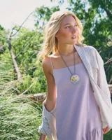 Collar con dije grande de bronce con forma de ostra y cordón de algodón ajustable color gris.