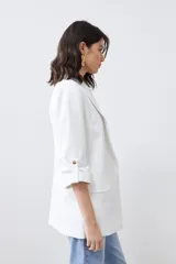 Blazer color crudo de corte recto, con cuello solapa, mangas 3/4 con botón y bolsillos frontales.