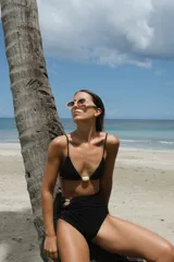 Top de bikini amarillo con textura acanalada, corte triangular, breteles regulables, pieza decorativa de resina verde en el centro y forro interno.