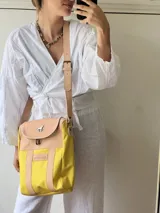 Bolso grande y espacioso, con diseño versátil en color amarillo, separado por velcro para funcionar como matera o cartera.