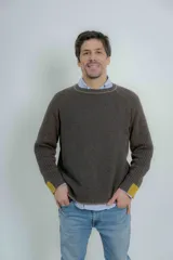 Sweater azul marino de hombre con cuello redondo y puños acanalados en color marrón.