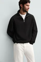Sudadera color crema de corte recto, con cuello polo y cierre de cremallera metálica.