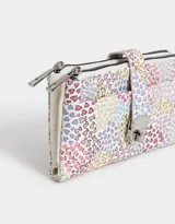 Billetera con formato de fichero, con estampado de corazones multicolores. Tiene doble compartimento con cierre superior y bolsillo frontal con lazo y broche metálico. Cuenta con compartimentos para tarjetas y billetes.