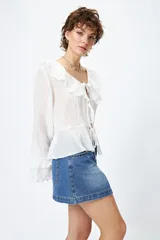 Minifalda de jean celeste con tiro bajo y detalle de tachas metálicas en los bolsillos.