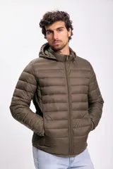 Campera capitoneada color verde con capucha y cierre frontal. Diseño acolchado y bolsillos laterales con cierre.