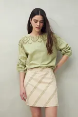Minifalda color beige con rayas diagonales verdes.
