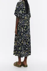 Vestido largo de viscosa con estampado paisley en tonos negro, amarillo y lila. Modelo de corte línea A, escote en V, manga corta y falda con fruncido en el bajo.