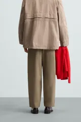 Pantalón verde militar de corte carrot fit, confeccionado en tejido de algodón. Cuenta con cintura elástica ajustable con cordón, bolsillos frontales y un bolsillo trasero de plastrón.