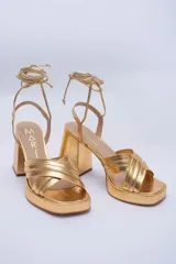 Sandalias rojas de cuero con plataforma y tiras para atar al tobillo.