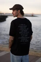 Remera negra de manga corta con cuello redondo y corte holgado. Estampa en la espalda con los títulos de canciones de la banda británica Oasis.