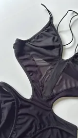 Body negro con breteles finos, escote en V y transparencias en el abdomen.