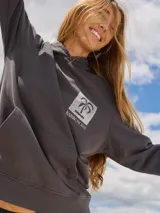 Buzo con capucha gris oscuro, con estampado trasero de motivos playeros y texto "Rainbow Bay The Goldcoast GEM".