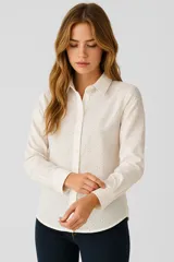 Camisa blanca de algodón con bordado calado, corte holgado, cuello camisero y cierre frontal con botones.