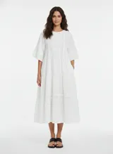 Vestido largo blanco de algodón con encaje, botones frontales, forro interior y corte regular.