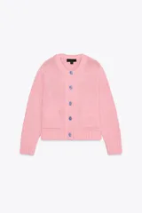 Chaqueta de punto rosa con cuello redondo y manga larga. Tiene bolsillos delanteros y cierre frontal con botones celestes.