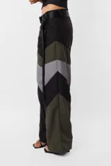 Pantalón negro de corte recto y tiro medio, con recortes en las piernas con detalle de vivo. Cintura con presillas y cinto correa con broche plástico incluido.
