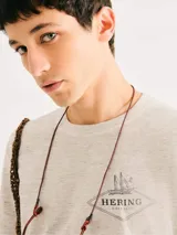 Camiseta blanca de algodón con cuello redondo y mangas cortas. Estampa rectangular con borde negro que contiene la frase "NATURAL ATMOSPHERE" en letras mayúsculas y una imagen de montañas y mar.