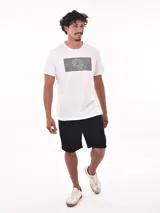 Remera color salmón con estampado rectangular con la palabra 'FEARLESS' en letras negras.