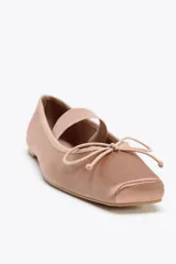 Zapato bailarina color rosa viejo, de efecto satinado, con punta cuadrada, tira elástica y lazo decorativo en la parte delantera.