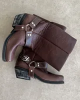 Bota alta de cuero vacuno color negro, con caña recta, punta cuadrada y estribo desmontable.