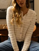 Cardigan de tejido tweed color blanco, marca Catherine Malandrino. Tiene cuello a la base, abertura central con botones perlados, bolsillos simulados en la delantera y bordados en lurex y lentejuelas.
