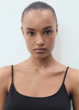 Mono largo negro de tirantes finos y corte recto, con cinturón fino trenzado.