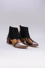 Botinetas de cuero con diseño patchwork en negro, dorado, plateado y marrón. Tienen elásticos laterales, taco cuadrado de madera y puntera fina.