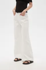 Pantalón de jean blanco, de corte ancho y tiro alto, con bordados de pequeñas tachas plateadas en los laterales.