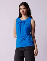Blusa sin mangas color amarillo, con cuello redondo con frunces delanteros y abertura con botón en la espalda.