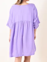 Vestido corto color lavanda, de corte suelto, con escote en V y mangas 3/4.
