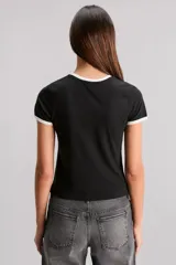 Remera blanca de calce slim, escote redondo y manga corta, con ribete negro en cuello y mangas. Estampa frontal de una frutilla roja con la frase "Bite Me".