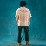 Remera oversize color beige con estampado de hongos y texto en marrón.