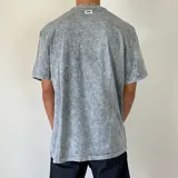 Remera gris con efecto gastado y cuello redondo.