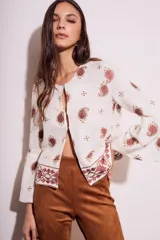 Blusa blanca con estampado de cachemir en color marrón y bordado floral en el ruedo y mangas acampanadas.