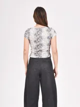 Remera manga corta con estampado de piel de serpiente en tonos grises.