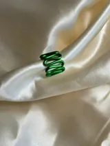 Anillo de aluminio color fucsia con forma ondulada.