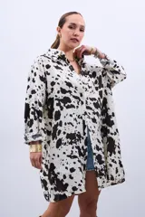 Camisa oversize blanca con estampado de manchas de vaca en color negro, de mangas largas y cuello camisero.