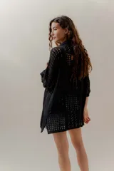 Saco calado negro tejido a máquina, con cuello tipo camisa y mangas 3/4.