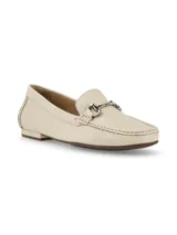 Mocasín de cuero color crema con detalle de hebilla metálica plateada.
