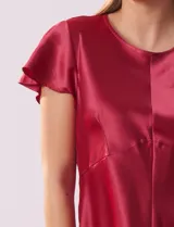Blusa plateada de satén con manga corta amplia, corte bajo el busto y abertura con botón en la espalda.