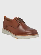 Zapato acordonado de cuero color marrón, con suela de goma color hueso.