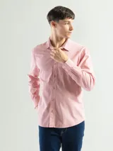 Camisa de manga larga color verde oliva, confeccionada en algodón. Tiene corte clásico, bolsillo en el lado izquierdo del pecho y cierre con botones.