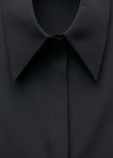Camisa negra de seda de mora con cuello camisero, corte recto, mangas largas con puños abotonados y cierre frontal con botones.