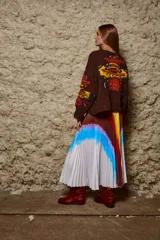 Sweater tejido de lana color marrón con bordado artesanal de flores en el frente y mangas. De calce holgado, cuello redondo y puños acanalados.